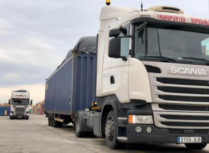 Un camión Scania blanco está estacionado en un estacionamiento.