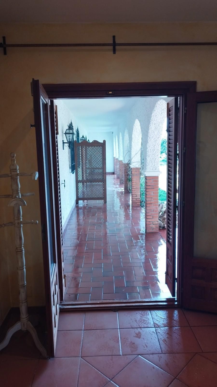 Al abrirse unas puertas dobles, se descubre un pasillo exterior