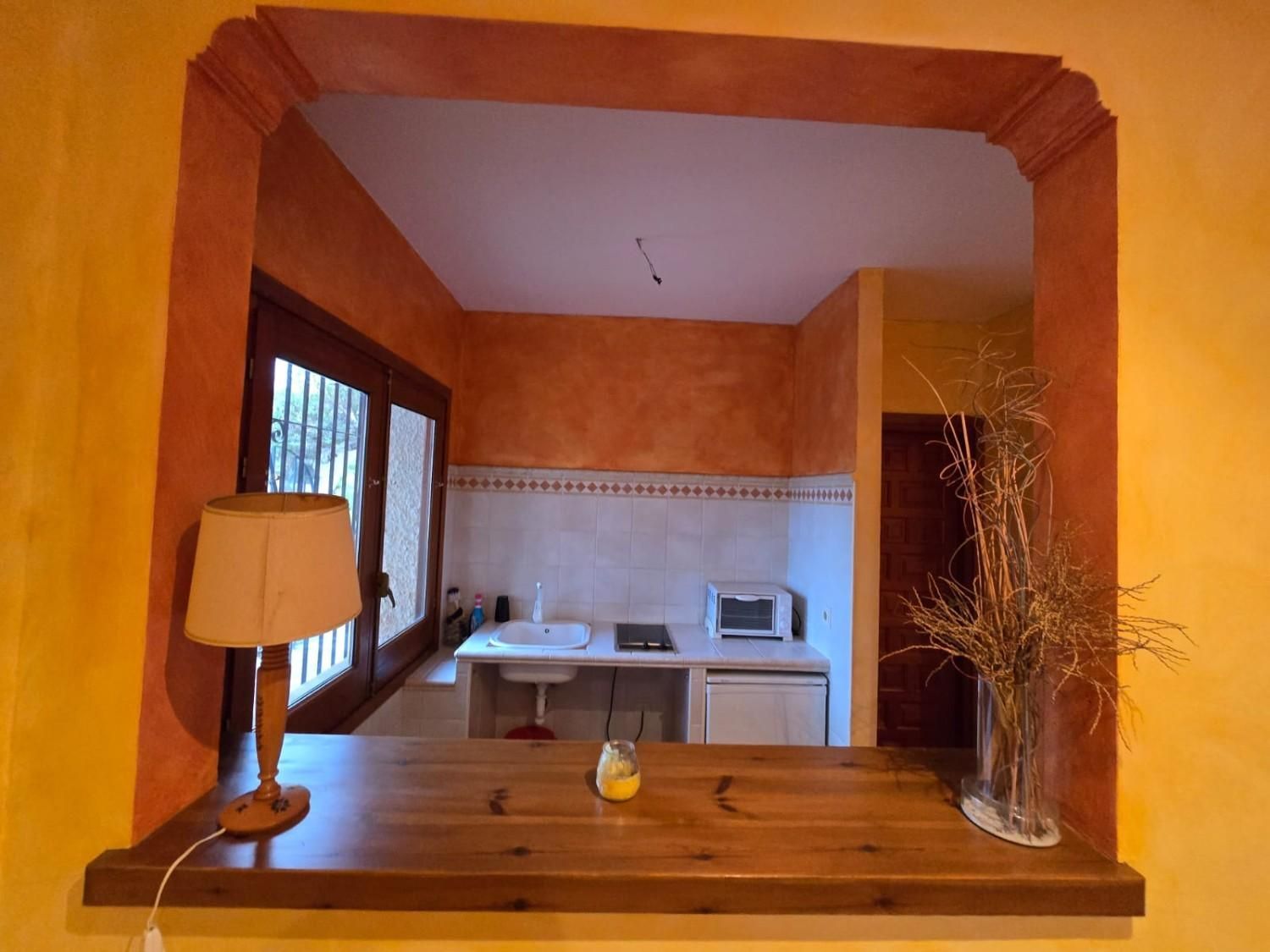 Una encimera de madera da a una pequeña cocina equipada 