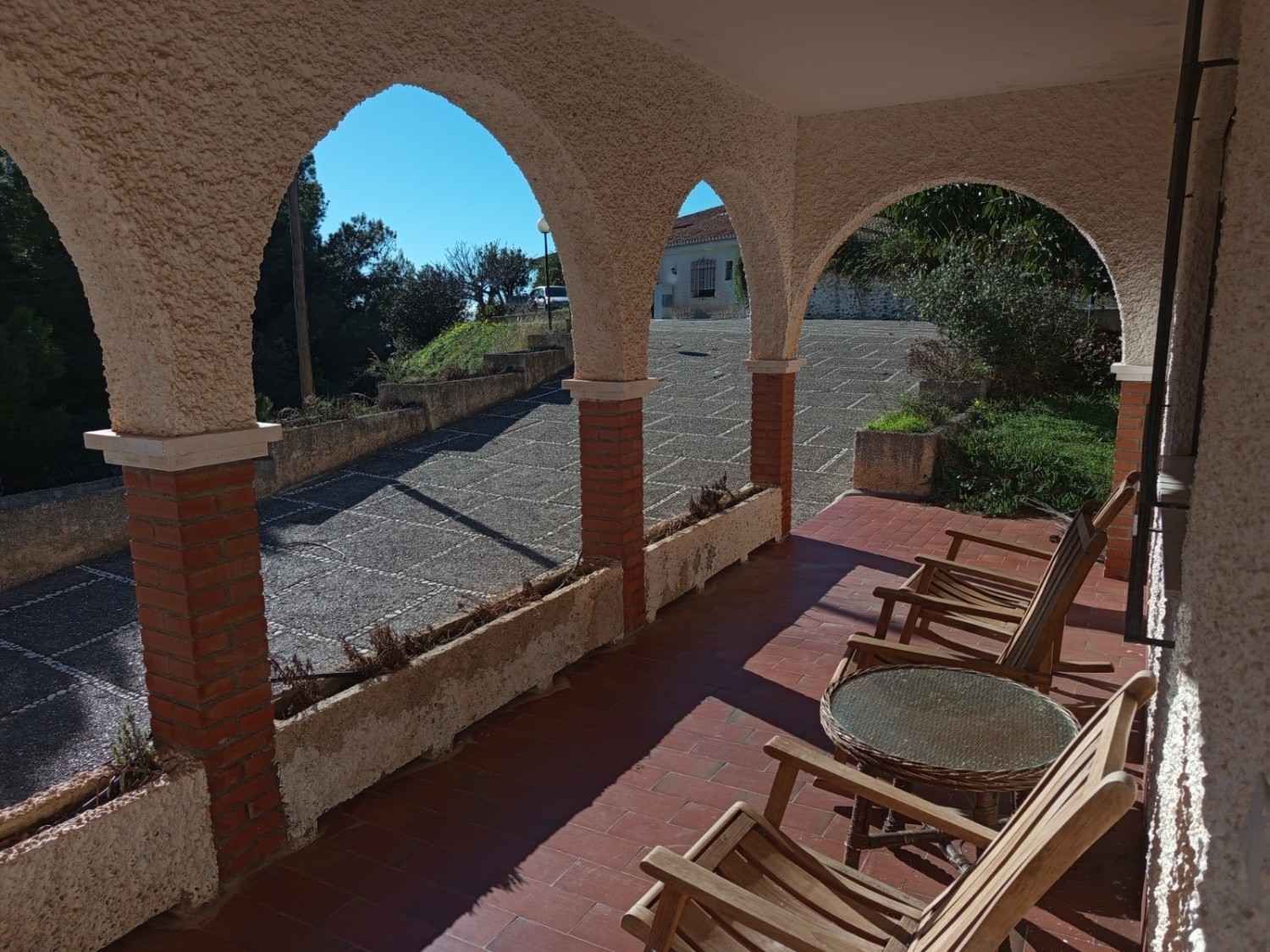 Un patio cubierto con pilares y arcos de ladrillo