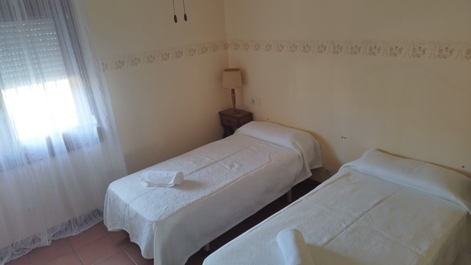 Una habitación de hotel con dos camas individuales blancas