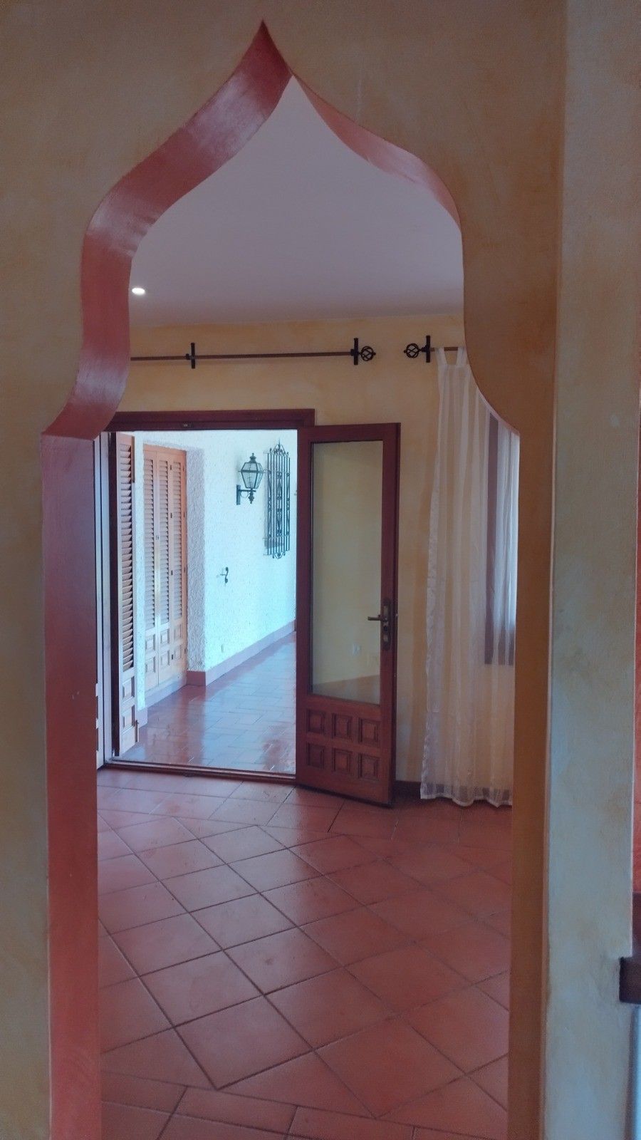 Vista a través de una puerta arqueada de estilo morisco hacia una habitación