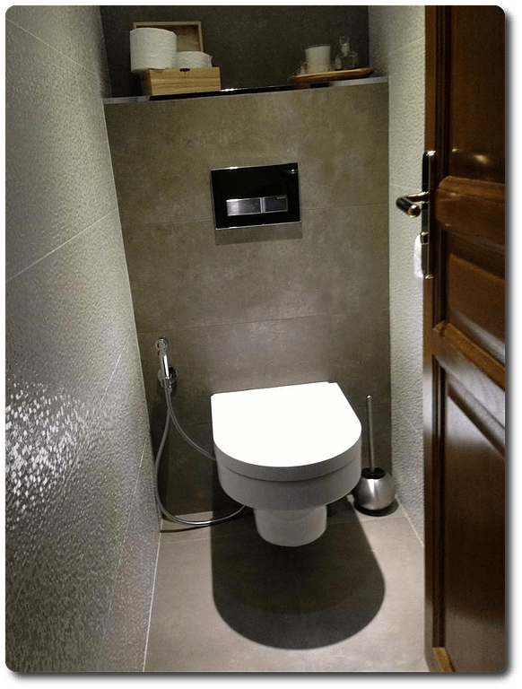 Toilettes avec béton ciré et porte en bois