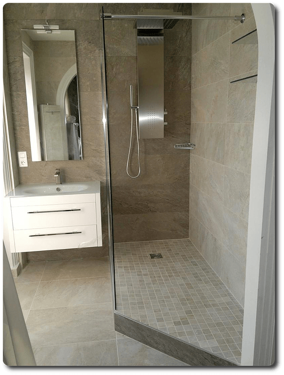 Meuble vasque blanc à deux tiroirs à côté d'une douche à l'italienne