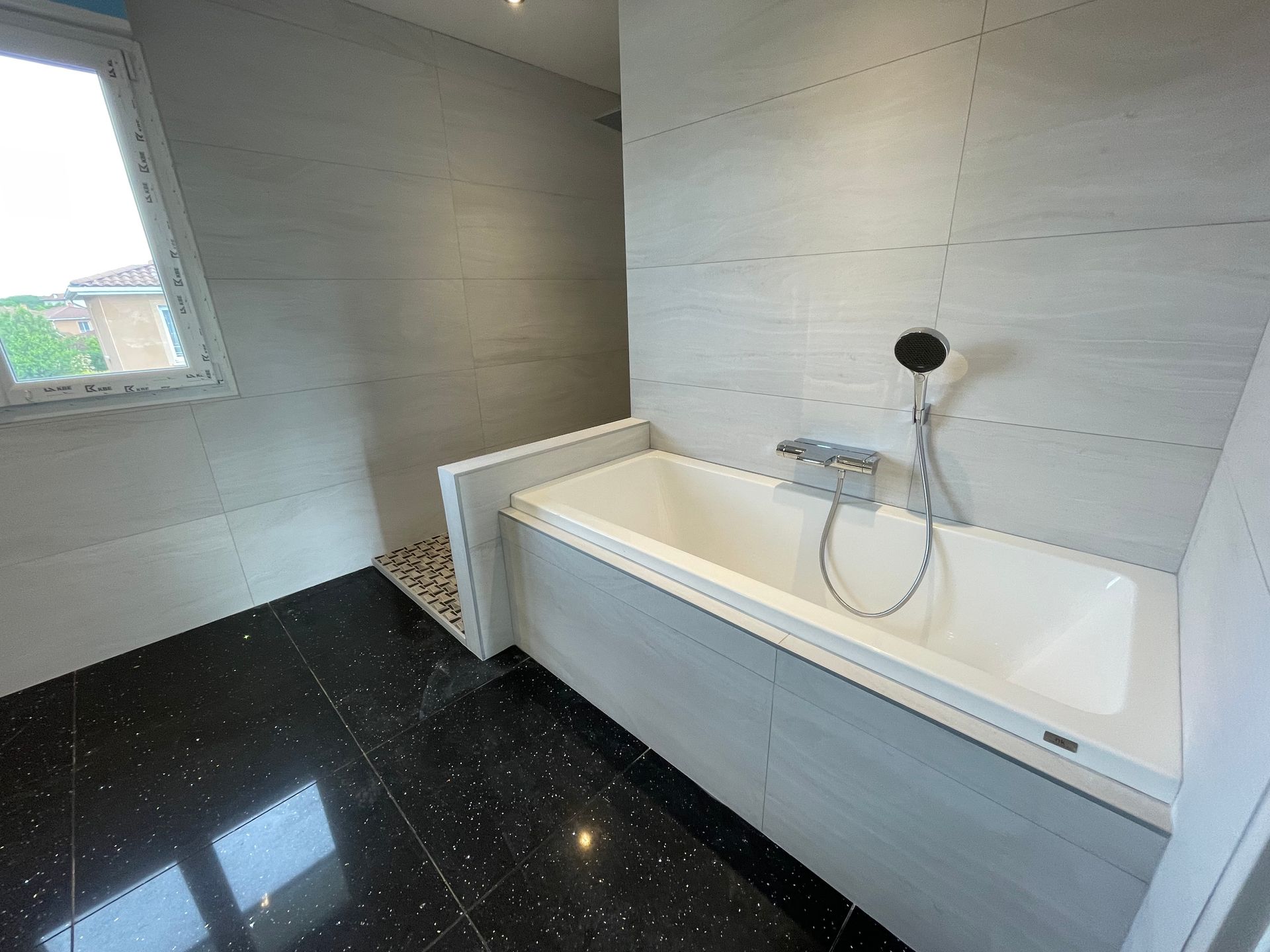 Baignoire blanche sur un sol noir