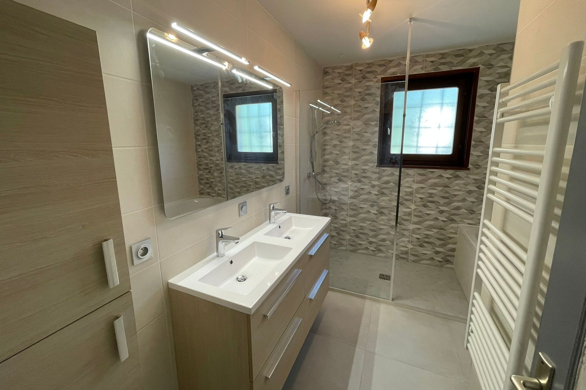 Salle de bains avec deux vasques et douche à l'italienne