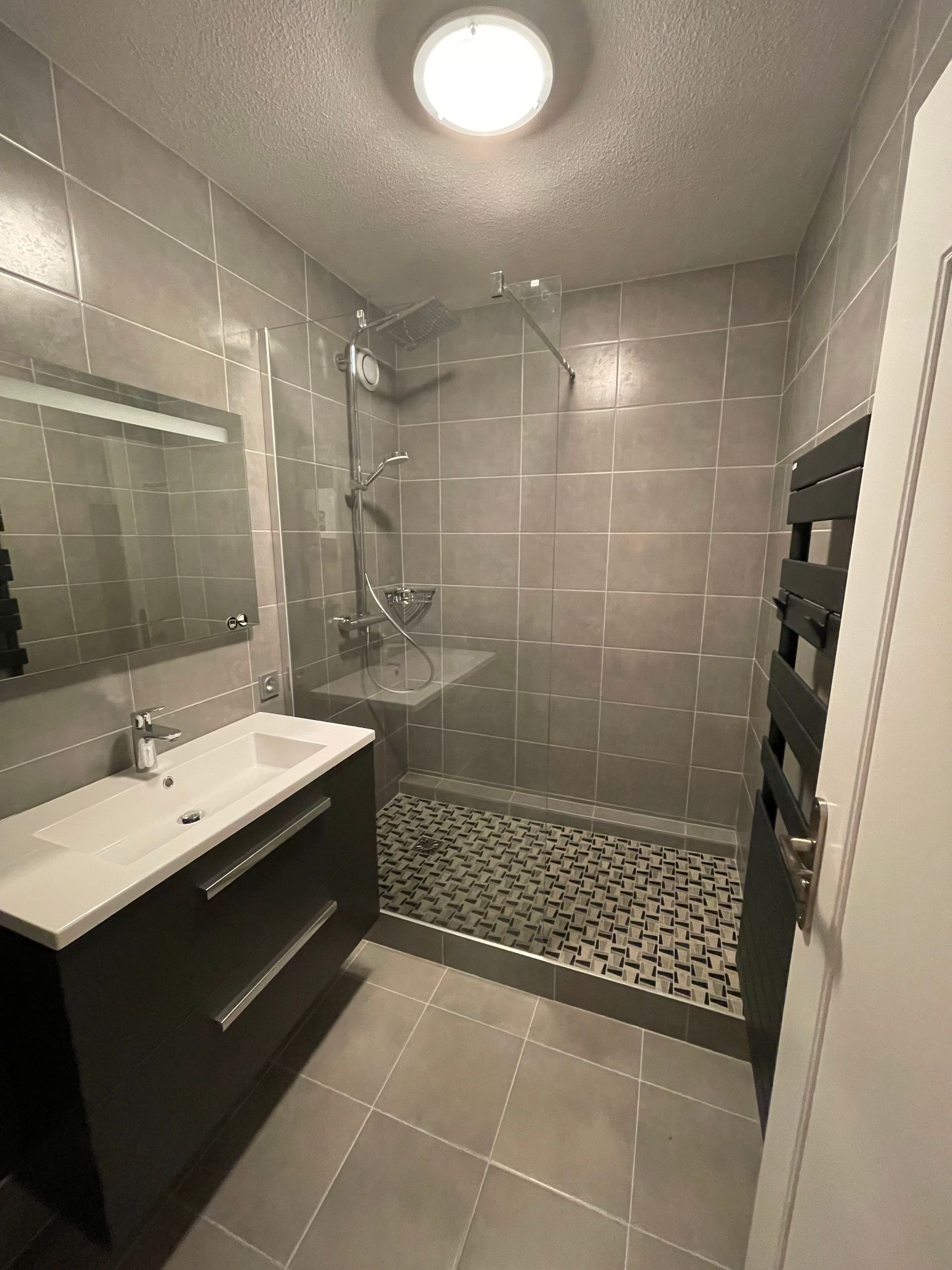 Salle de bains avec meuble vasque et sèche-serviette gris