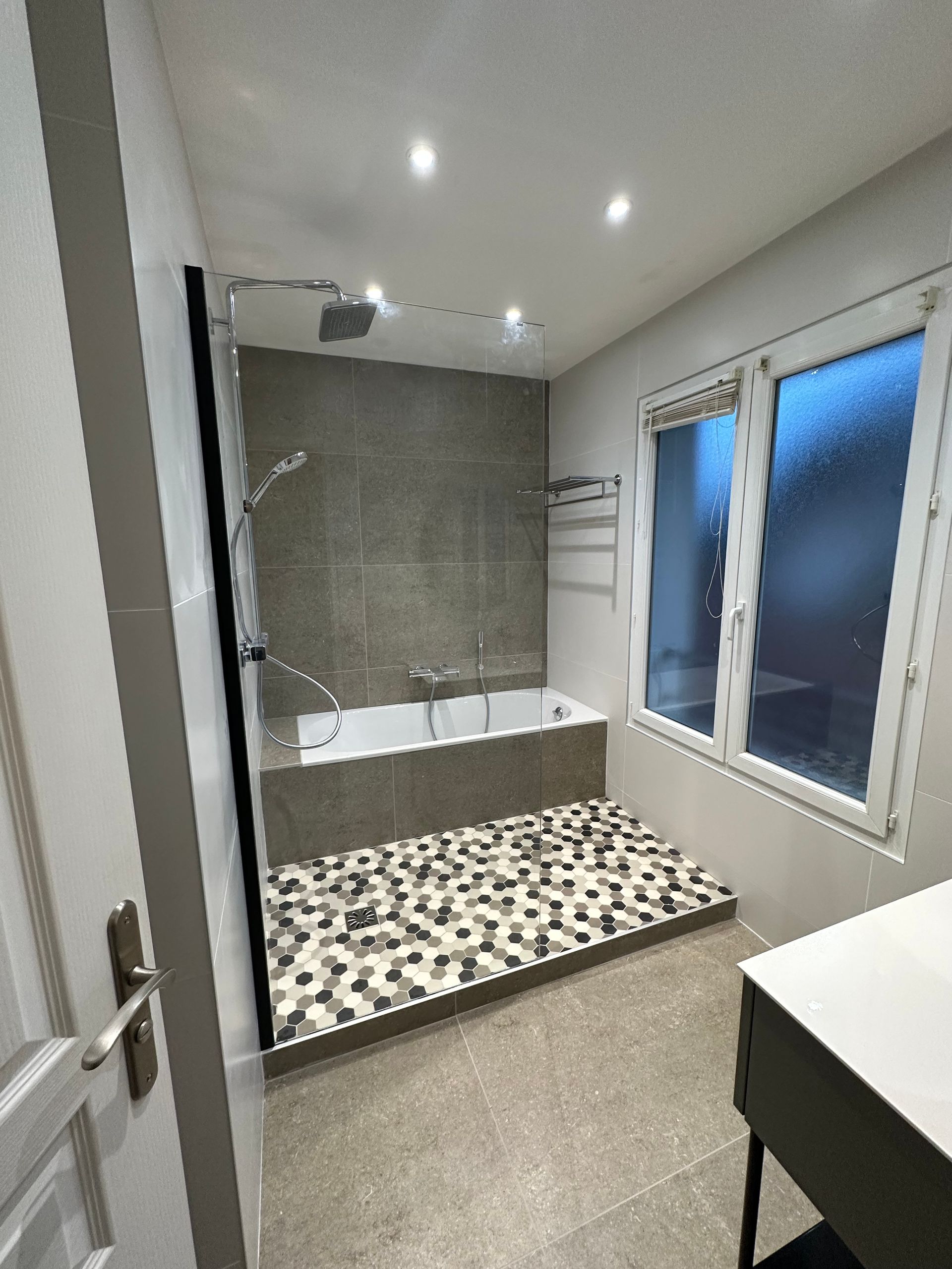 Douche à l'italienne avec un sol avec hexagone devant une fenêtre