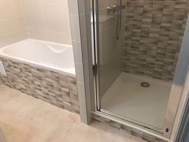 Douche-cabine à côté d'une baignoire avec motif assorti