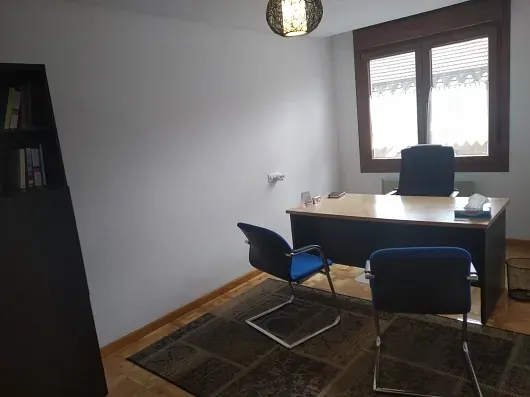 Una pequeña oficina con un escritorio y dos sillas.