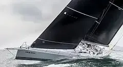 Velero con velas negras navegando en el agua.