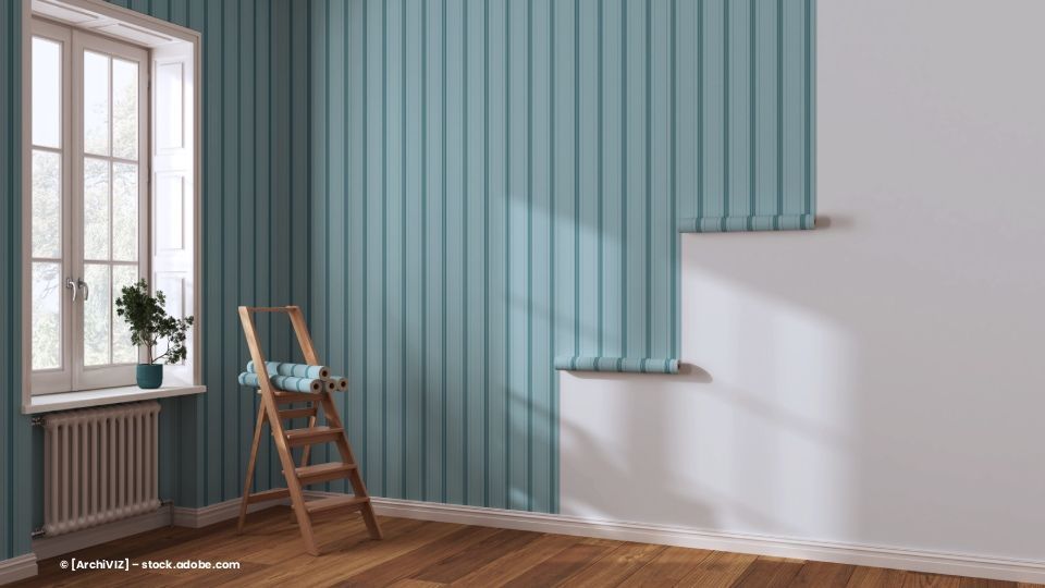 Innenraum mit blau gestreifter Wand, Fenster, Leiter und teilweise tapezierter Wand.