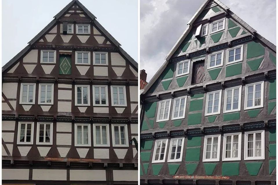 Zwei Fachwerkhäuser mit dreieckigen Giebeldächern; eines ist braun-weiß, das andere grün-weiß.