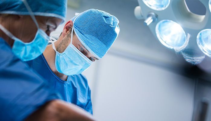 Deux chirurgiens opèrent un patient dans une salle d'opération.