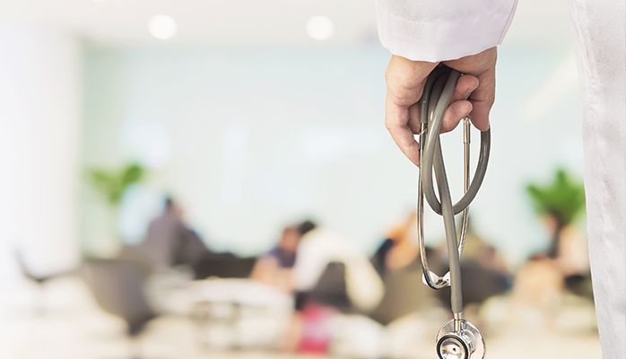 Un médecin tient un stéthoscope dans la salle d'attente d'un hôpital.