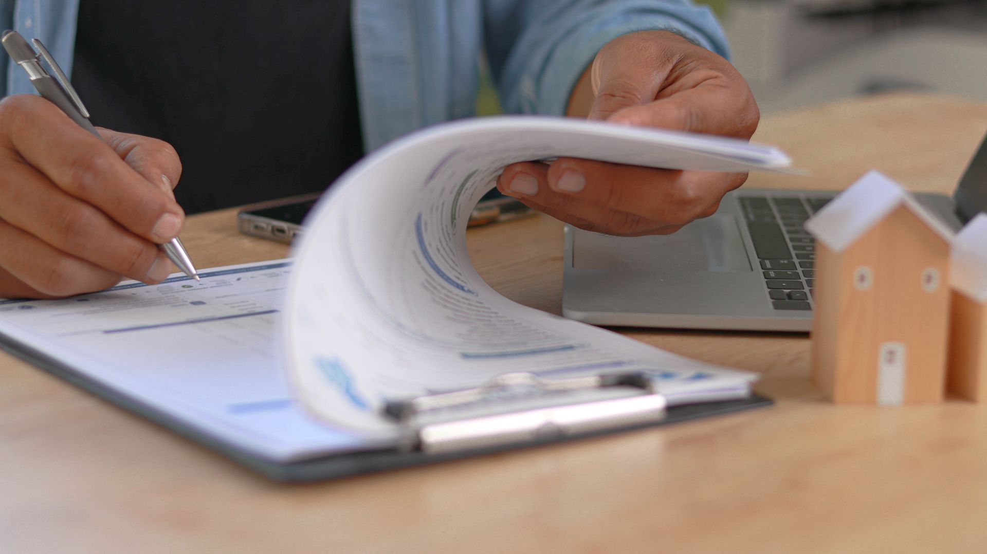 Une personne écrit sur un dossier en papier.
