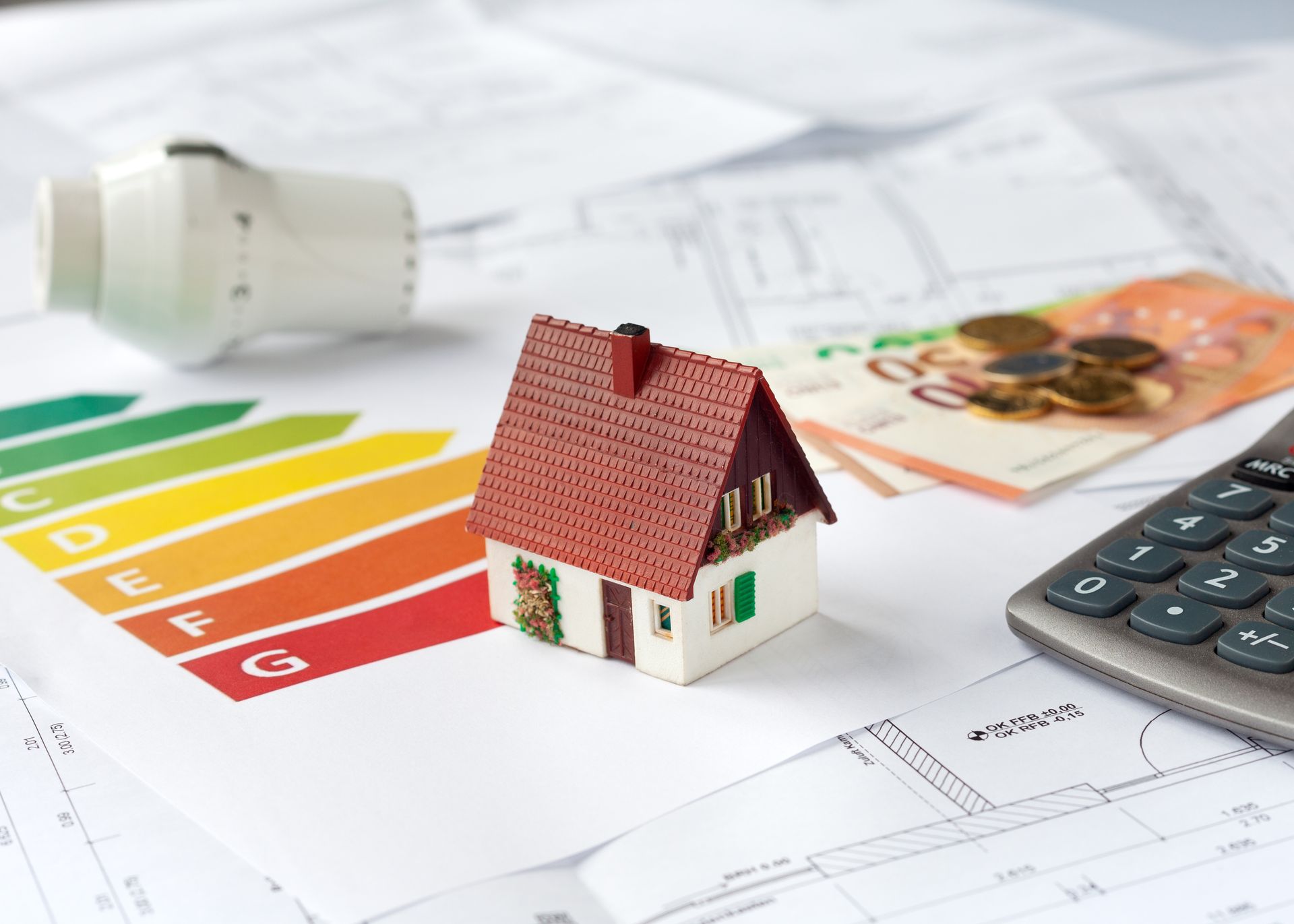 Maison sur un graphique d'efficacité énergétique avec ampoule et calculatrice.