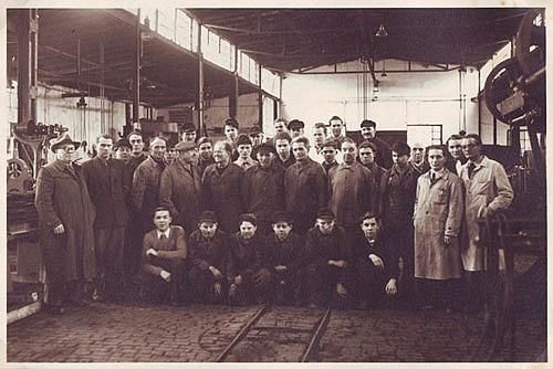 Eine Gruppe Männer posiert in einer Fabrik für ein Foto.