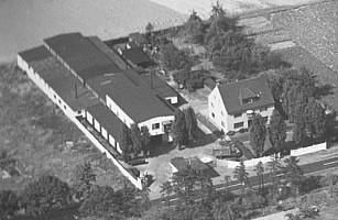 Eine Luftaufnahme eines großen, von Bäumen umgebenen Gebäudes in einem Schwarzweißfoto.