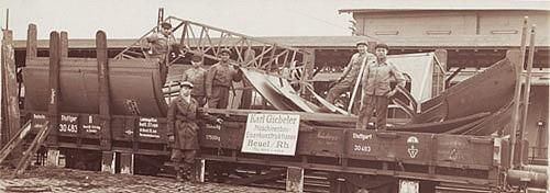 Eine Gruppe Männer steht neben einem Zugwaggon.