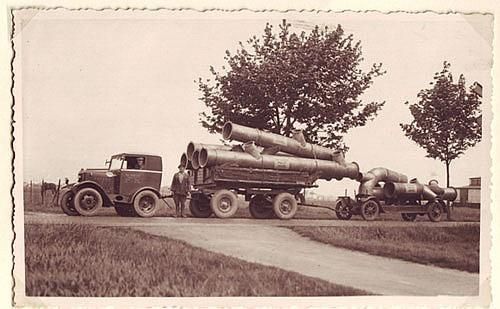 Ein Schwarzweißfoto eines LKWs mit Rohren