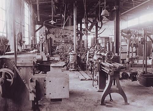 Ein Schwarzweißfoto einer Fabrik mit vielen Maschinen.