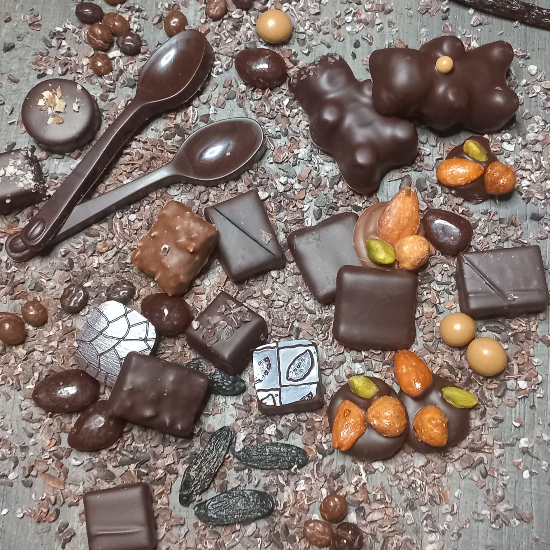 Des rangées de gelées de fruits carrées et colorées sur une grille, avec des couleurs comme le jaune, l'orange, le rouge et le violet.