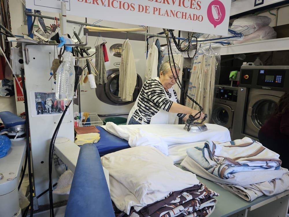 Una fila de camisas blancas están colgadas en un perchero.