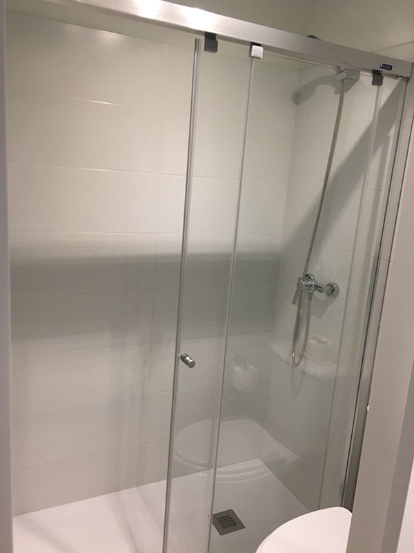 Un baño con puerta de ducha corrediza de cristal y un inodoro.