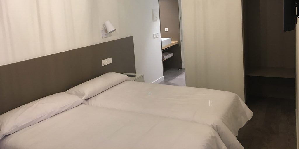 Una habitación de hotel con dos camas y un baño.