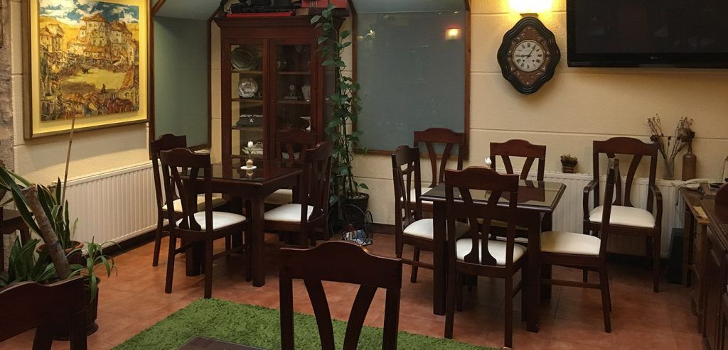 Una habitación con mesas y sillas y un reloj en la pared.