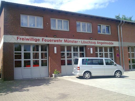 Ein weißer Lieferwagen steht vor einem Gebäude mit der Aufschrift „Freiwillige Feuerwehr“