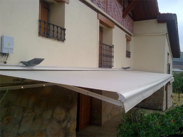 Un toldo retráctil blanco de gran tamaño montado 