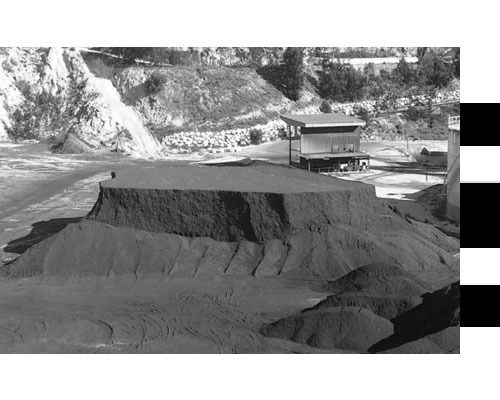 Una fotografía en blanco y negro de un montón de tierra en un campo.