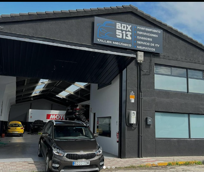 Un coche está aparcado delante de un edificio que dice box 513