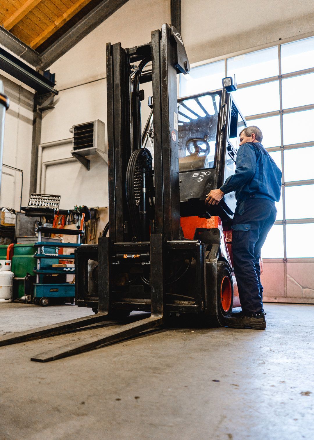 Mitarbeiter steht neben einem Gabelstapler