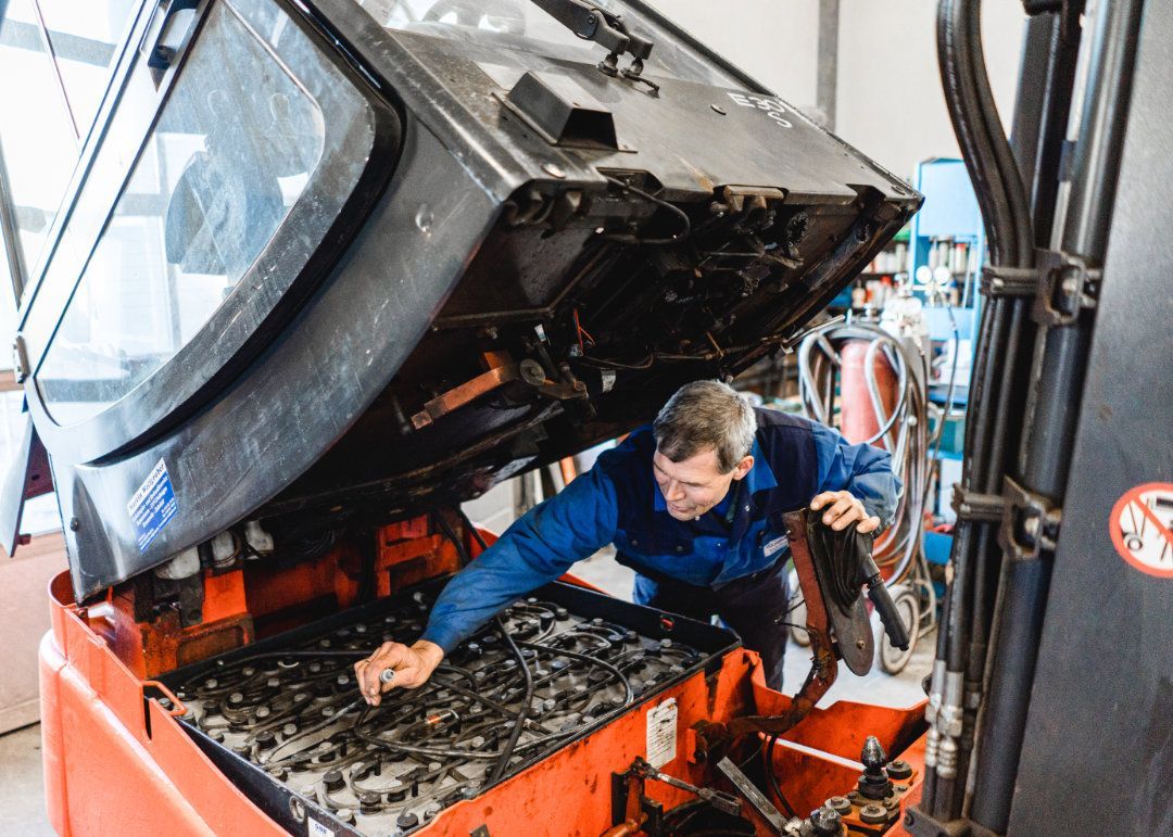 Mitarbeiter arbeitet an einem aufgekippten Gabelstapler