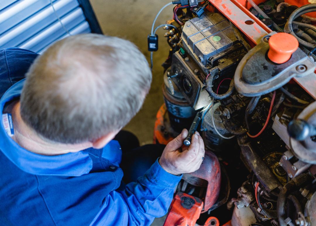 Mitarbeiter arbeitet an einem Kabel an einem Gabelstapler.