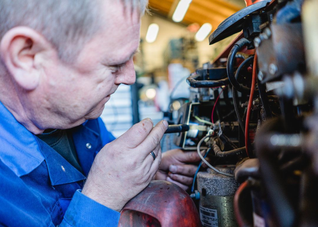 Mitarbeiter arbeitet an einem Kabel an einem Gabelstapler.