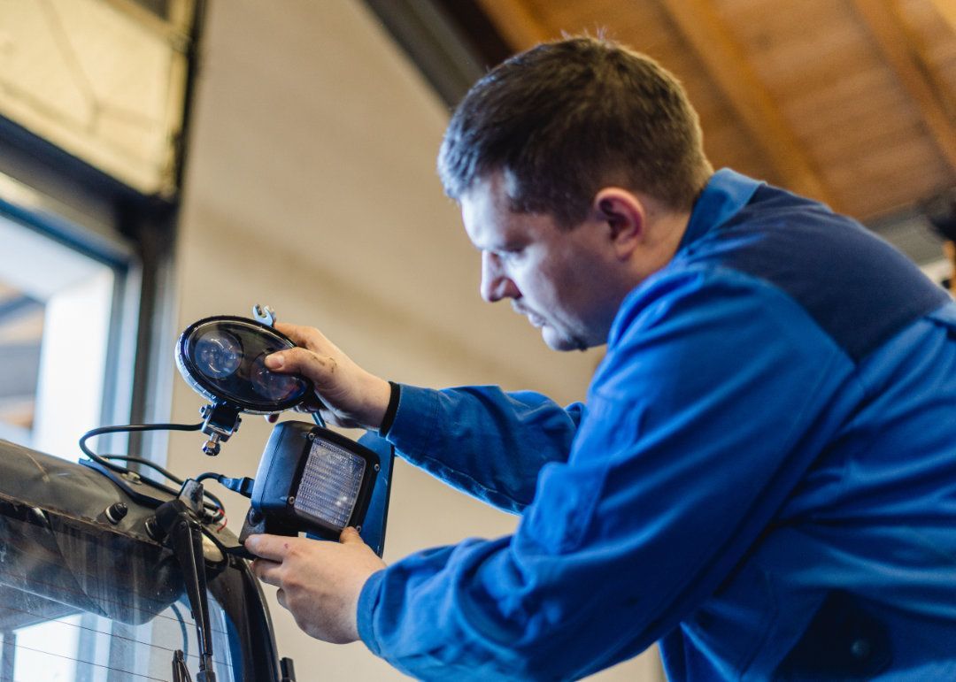 Mitarbeiter wechselt das Licht an einem Gabelstapler