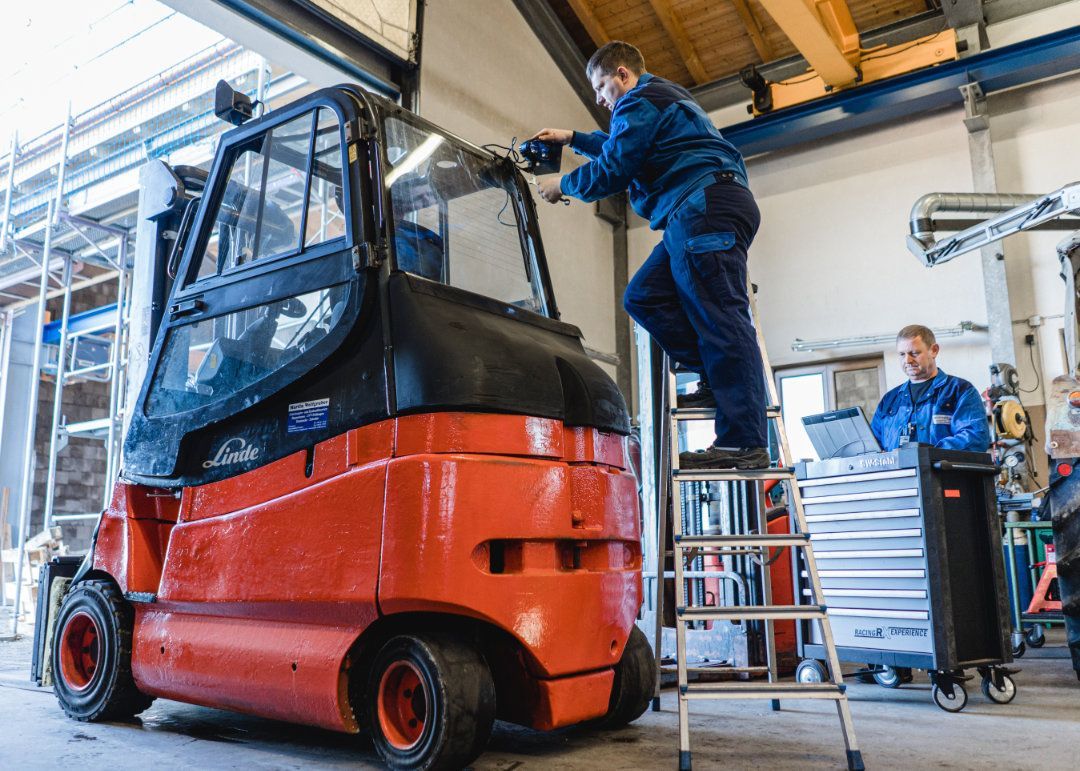 Mitarbeiter arbeitet an einem Gabelstapler