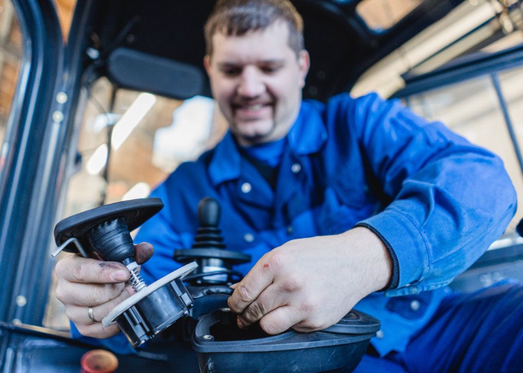Mitarbeiter wechselt etwas in einem Gabelstapler aus