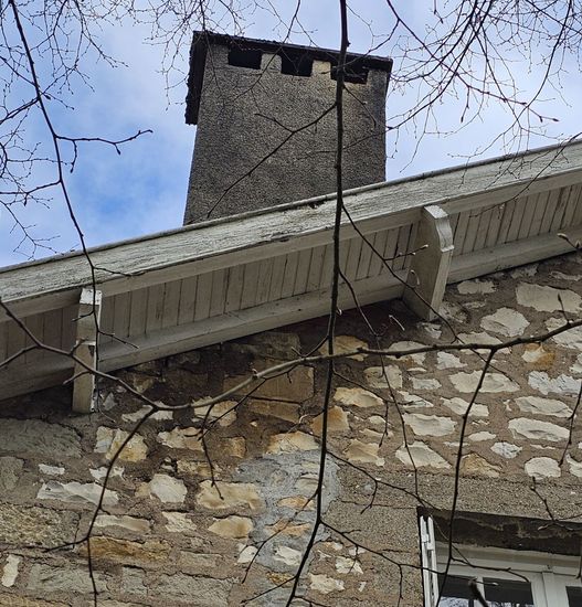 Coin de pièce blanc nu avec un petit crochet mural et une partie du cadre de la fenêtre visibles