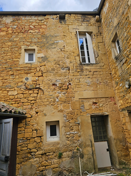 Coin de mur et de plafond carrelé en blanc avec un cadre de porte et des fissures ou des dégâts d'eau visibles.