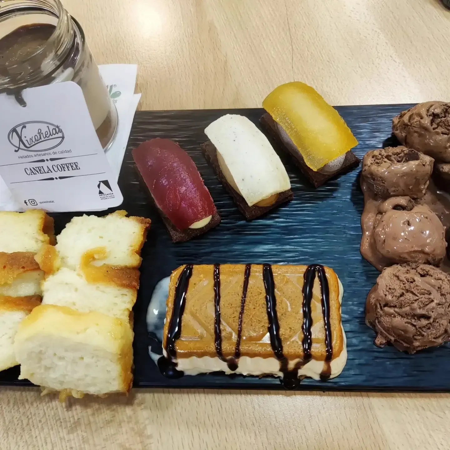 Surtido de postres y pasteles coloridos dispuestos en un plato de pizarra