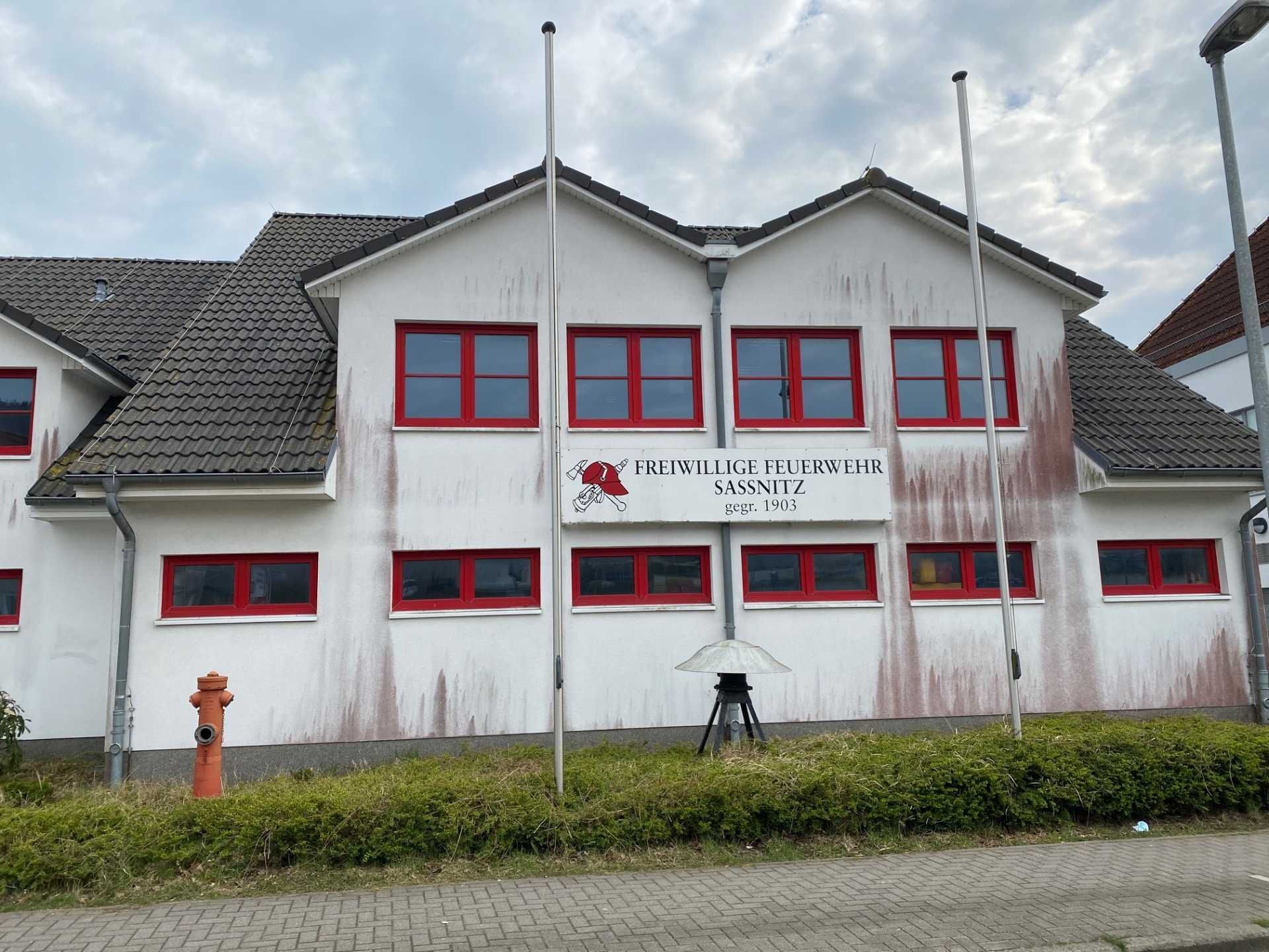 Ein weißes Gebäude mit roten Fenstern und einem Schild Freiwillige Feuerwehr Sassnitz