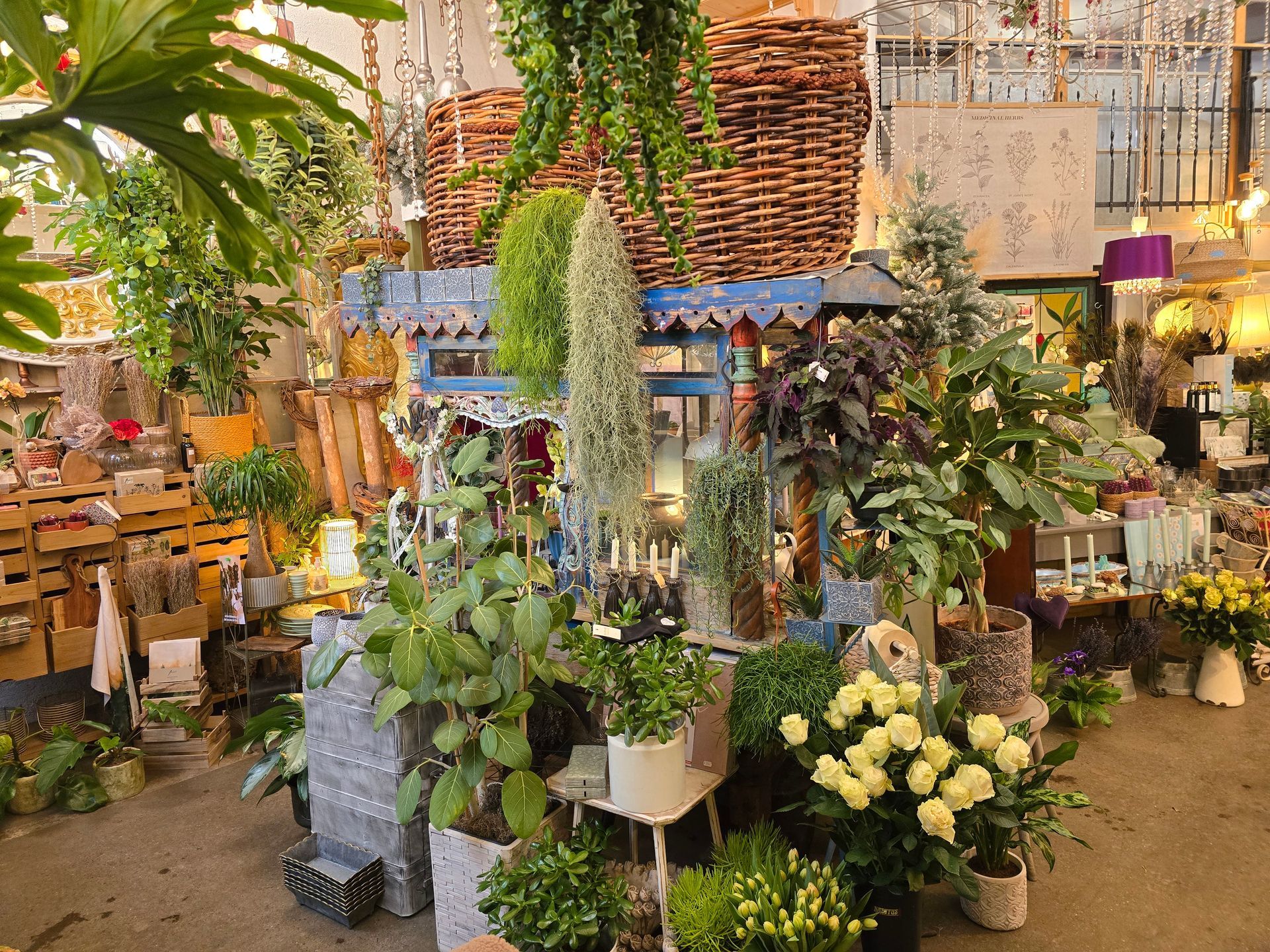 Eine Kerze steht auf einem Teller auf einem Tisch, umgeben von Blumen.