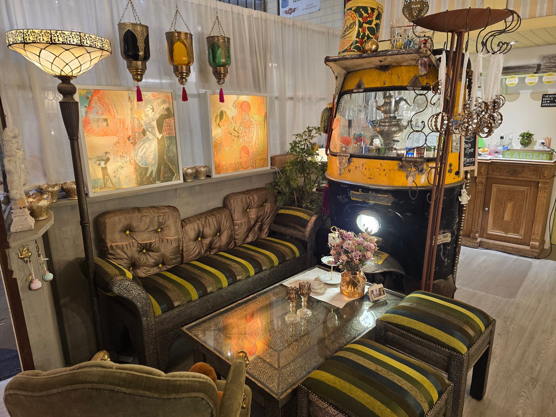 Ein Wohnzimmer mit Sofa, Tisch, Stühlen und einer Rikscha im Hintergrund.