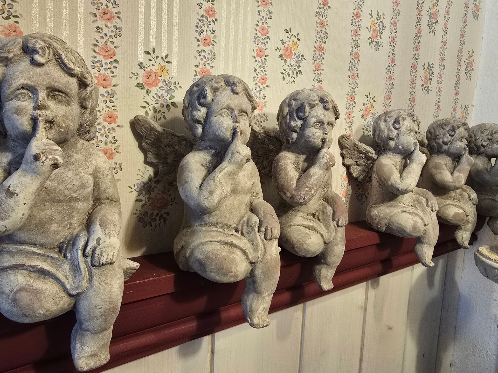 Eine Reihe von Engelsstatuen, die auf einem Regal sitzen