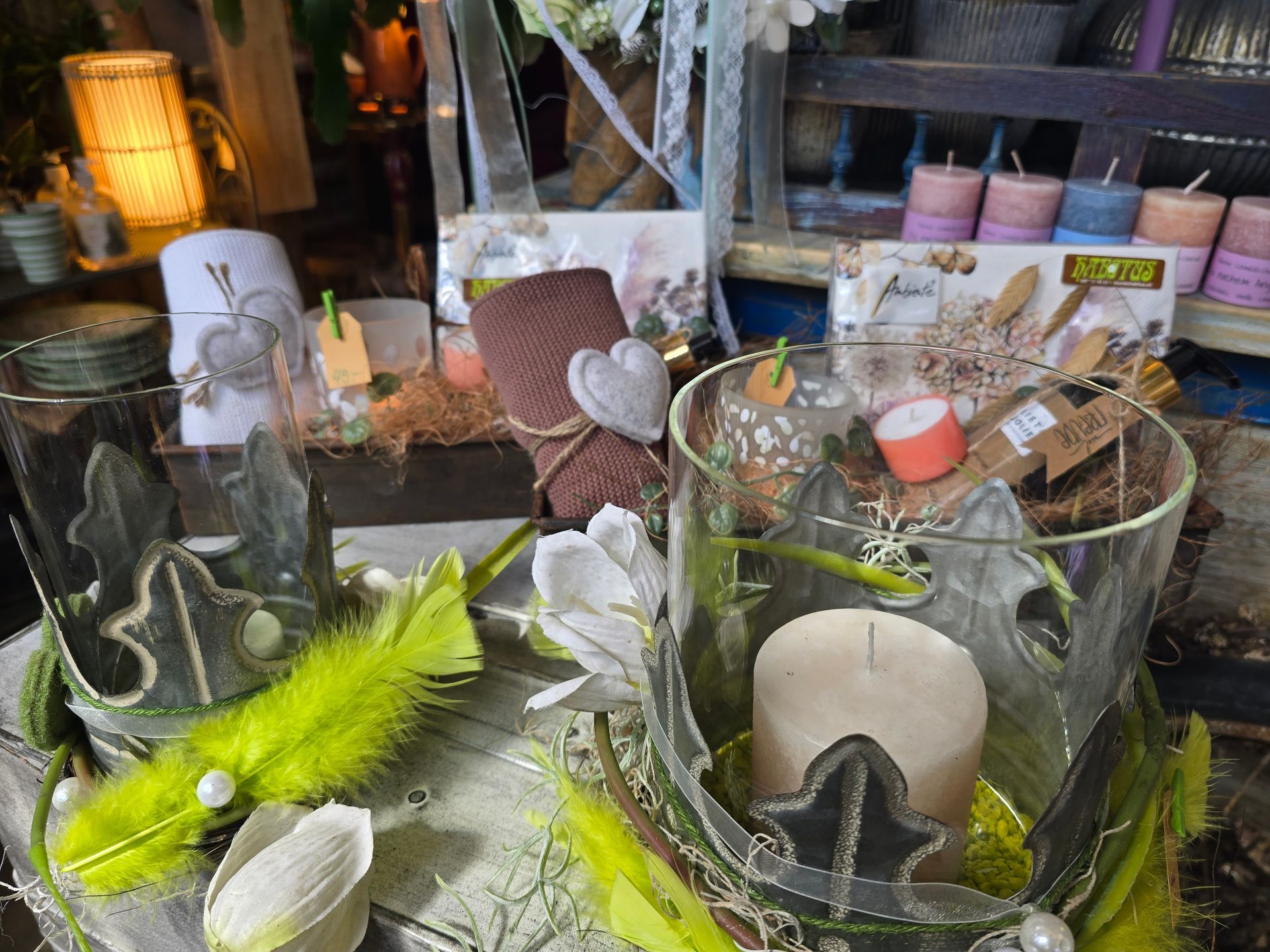 Ein Glasbehälter mit einer Kerze darin auf einem Tisch.